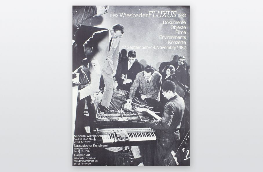 Ausstellungsplakat zeigt s/w Foto von einem Fluxus Konzert, auf dem Menschen einen Flügel demontieren