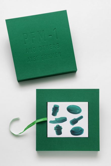 Edition von Ayse Erkmen. Eine quadratische, grüne Schachtel, auf dem Deckel ist eingeprägt: PFM-1 AND OTHERS. AYSE ERKMEN. In der Schachtel sind die DVDs in einer Hülle, auf der die unterschiedlichen Minen abgebildet sind.