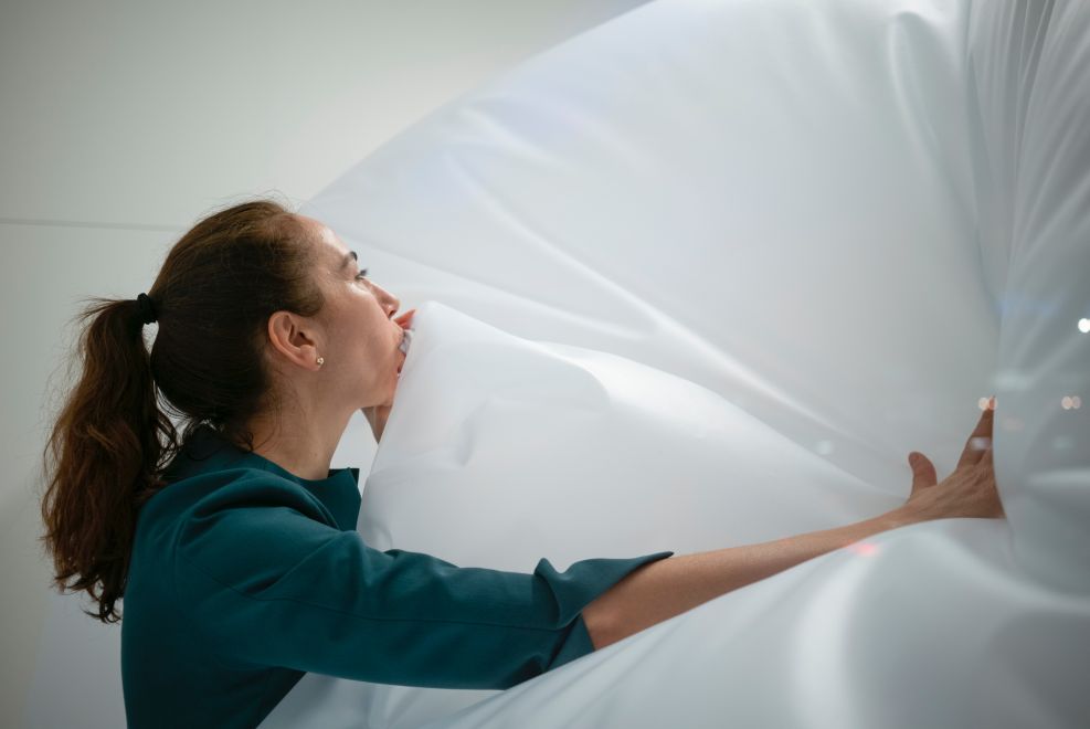 Close-up of the artist Mehtap Baydu during her performance ATEM, during which she inflates a large transparent balloon in a Berlin shop window for 18 days using only her breath.