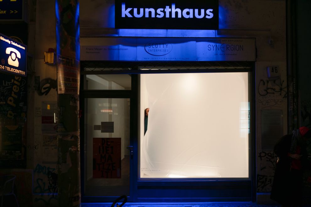 The artist Mehtap Baydu during her performance ATEM, in which she inflates a large transparent balloon in a Berlin shop window for 18 days using only her breath. The artist is pressed against the wall by the ever-growing balloon and can almost no longer be seen.
