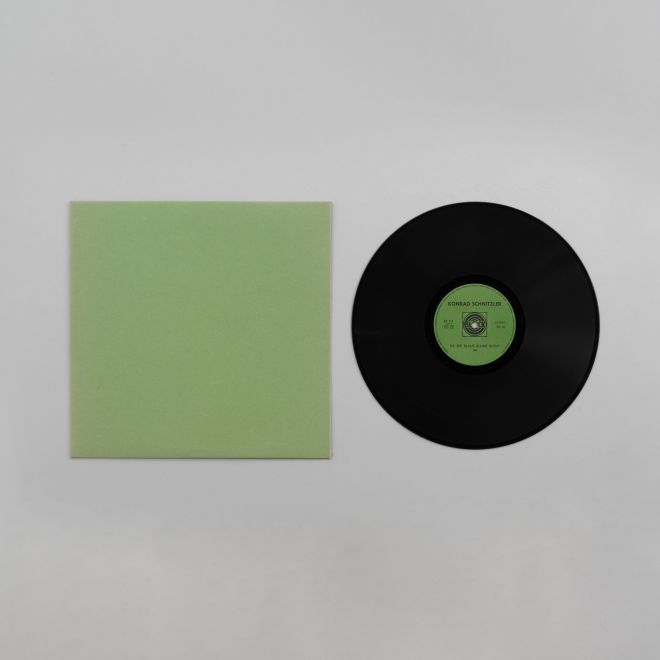 LP von Conrad Schnitzler. Eine LP mit grünem Label liegt neben ihrer grünen Hülle ohne Aufdruck