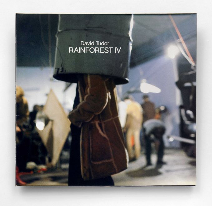 LP by David Tudor. On the cover is a photo of a sound sculpture. A man is standing with his head in a barrel hanging from the ceiling. Other people and sculptures are blurred in the background