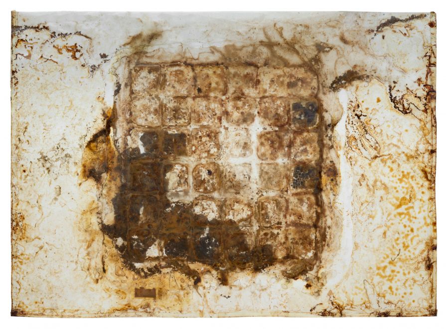 Multiple by Dieter Roth. Material image: 36 After Eight were arranged as a square between two large-format rectangular plastic sheets, poured with yoghurt and vacuum-sealed. The chocolate decomposed over time, so that the strict grid dissolved and only remnants of it can still be seen.