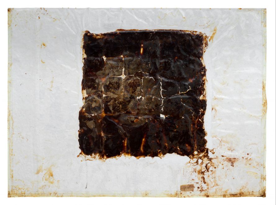 Multiple by Dieter Roth. Material image: 36 After Eight were arranged as a square between two large-format rectangular plastic sheets, poured with yoghurt and vacuum-sealed. The chocolate decomposed over time, dissolving the strict grid and creating an uneven surface of brown tones.