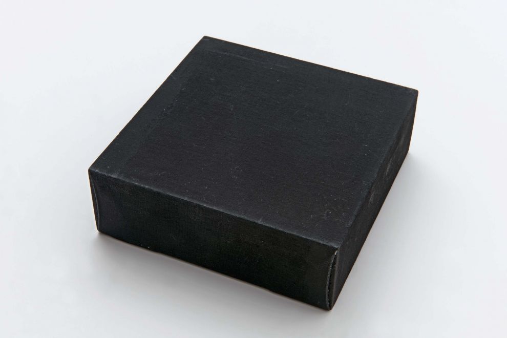 Multiple von Palermo. Ein mit schwarzem Leinen bezogener quadratischer Holzkasten