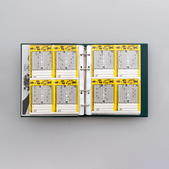 Multiple by Sigmar Polke. An open ring binder. Eight completed and numbered lottery tickets can be seen in transparent sleeves.