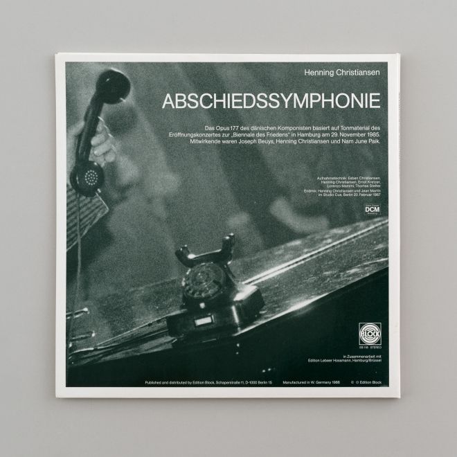 LP Hülle Rückseite. Ein schwarz-weißes Detail-Foto vom Konzert. Auf einem Flügel steht ein altes Telefon, dessen Hörer abgenommen wird. Darüber in weiß: Henning Christiansen. ABSCHIEDSYMPHONIE und ein kurzer Text zur LP