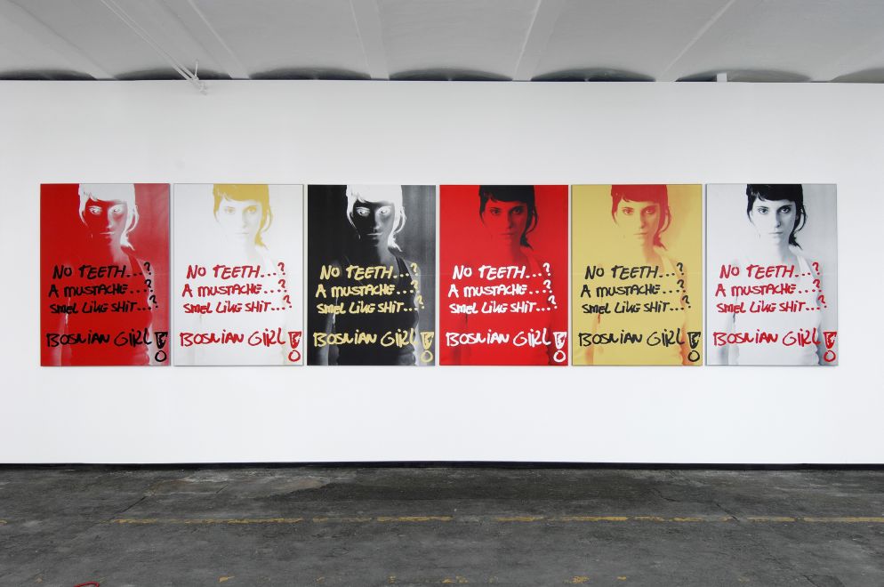 Ausstellungsansicht. 6 Siebdrucke mit dem selben Motiv in unterschiedlicher Farbigkeit hängen in einer Reihe an einer Wand. Auf den Drucken ist Sejla Kameric zu sehen. Darüber steht im Stil eines Grafittis: no teeth…? a moustache…? smel like shit…? BOSNIAN GIRL!