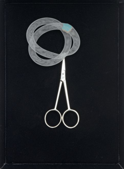 Edition von Gülsün Karamustafa. Blick auf die geöffnete schwarze Samtschatulle mit einer Schere und einem Netz mit einer kleinen Scherbe