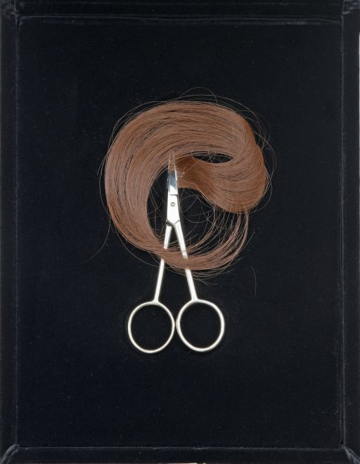 Edition von Gülsün Karamustafa. Blick auf die geöffnete schwarze Samtschatulle mit einer Schere und Haarsträhne