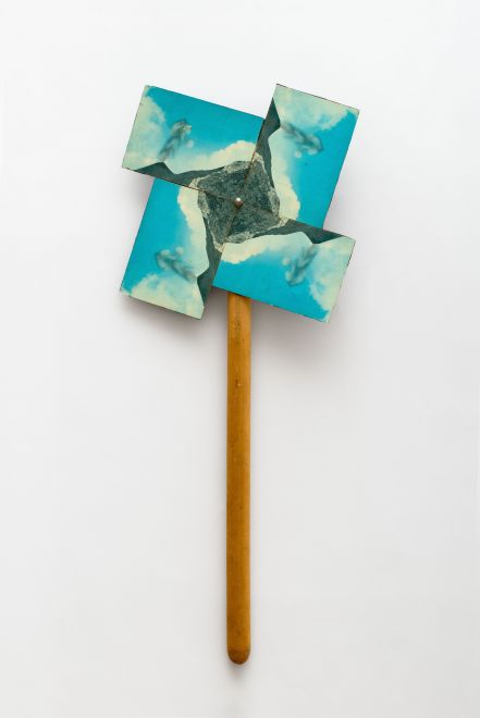 Multiple von KH Hödicke. Vier identische Postkarten mit einer Ansicht der Insel Stromboli an einem Holzstiel angebracht, es sieht aus wie ein Windrad. In der Anordnung der Karten, die den aktiven Vulkan der Insel zeigen, wird die eruptierende Asche zur visuellen Antriebsdüse eines Windrades.