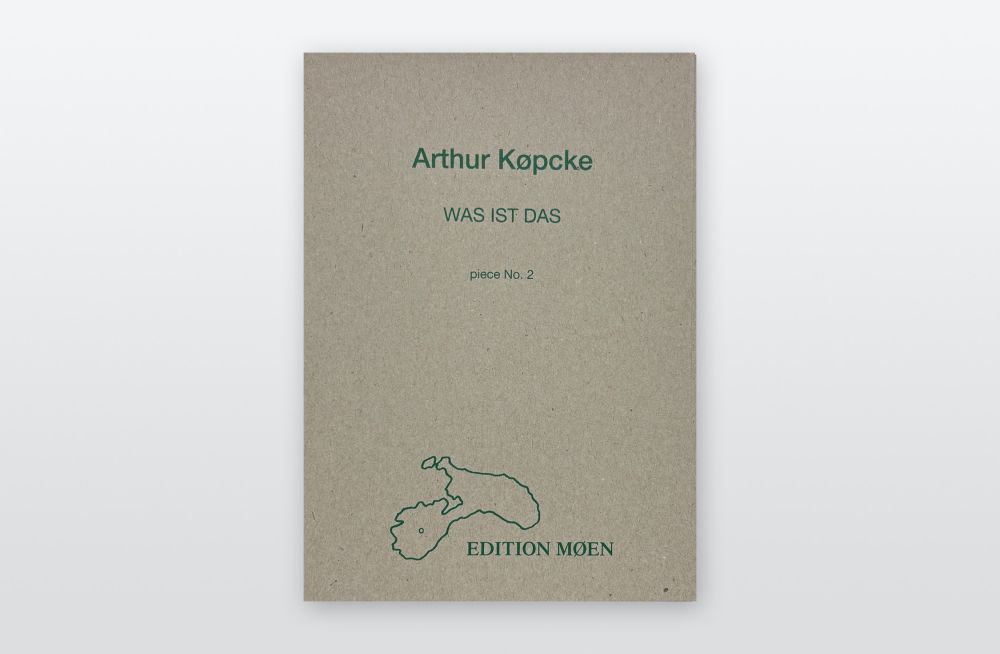 Eine Kassette aus Karton liegt auf hellgrauem Hintergrund. Sie trägt die Aufschrift in grün: Arthur Köpcke, WAS IST DAS. EDITION MOEN