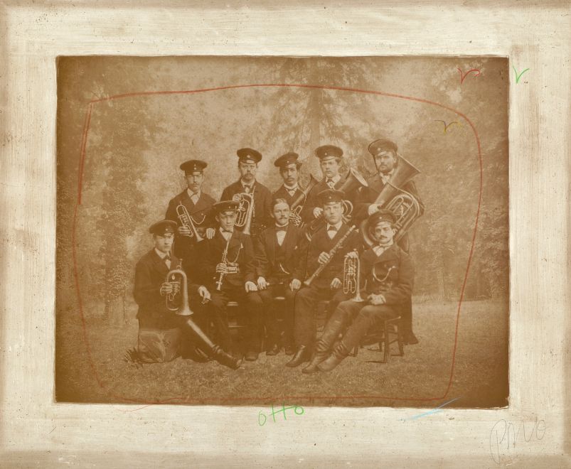 Kunstwerk von Nam June Paik. Eine Fotografie in Sepia zeigt eine MilitärBlaskapelle zu Beginn des 20. Jahrhunderts. Darüber hat Paik mit Kreide die Form eines Bildschirms und einige fliegende Vögel gemalt, sowie den Namen Otto geschrieben