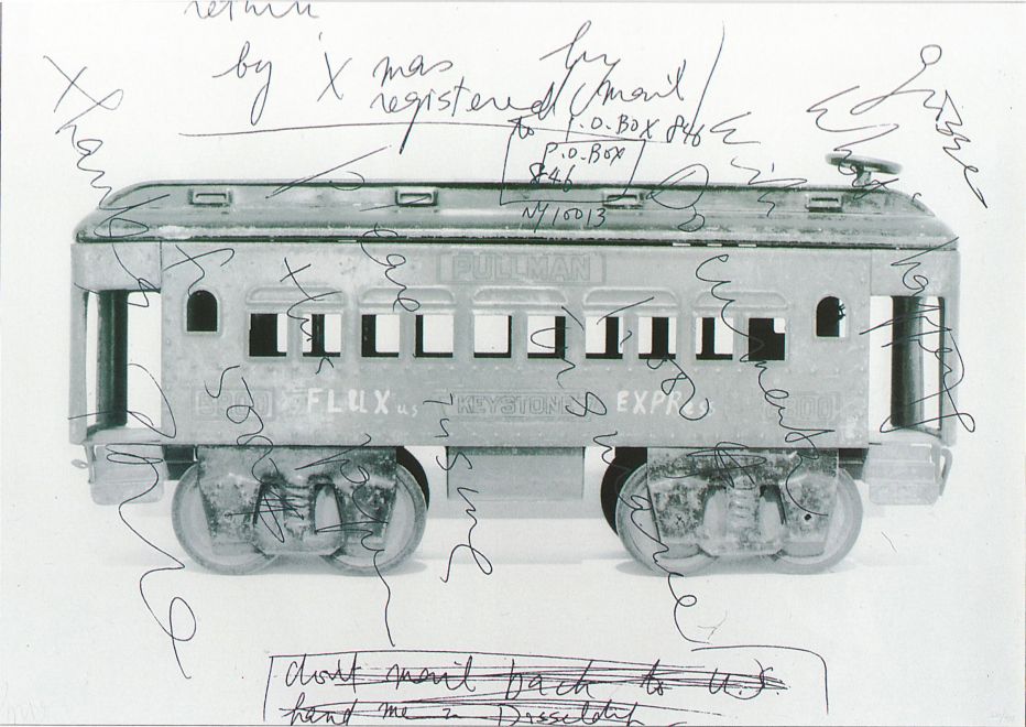 Screen print on offset print by Nam June Paik shows a black and white photo of a toy train wagon with FLUXus EXPRess written on it. Paik's handwritten notes from letters are printed over it in screen print