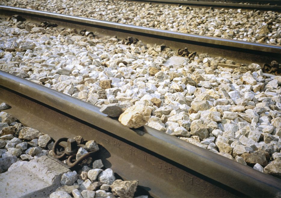 Offsetdruck von Bülent Sangar. Bahngleise und Kieselsteine, zwei Steine liegen auf einer der Schienen