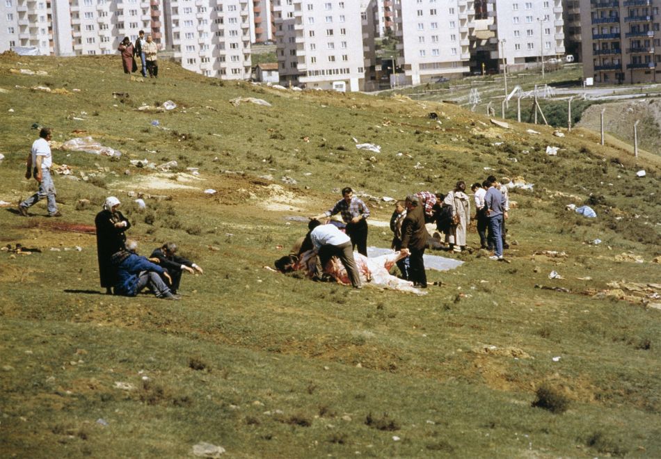 Offsetdruck von Bülent Sangar. Auf einer abschüssigen Wiese sind mehrere Personengruppen, eine Gruppe bearbeitet ein großes Opfertier. Im Hintergrund sieht man Wohnblöcke