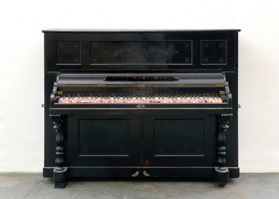 Multiple by Carles Santos. Ein gebrauchtes Klavier, dessen Tasten mit Fotos beklebt sind