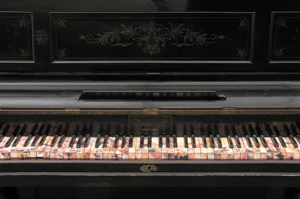Multiple by Carles Santos. Ein gebrauchtes Klavier, dessen Tasten mit Fotos beklebt sind