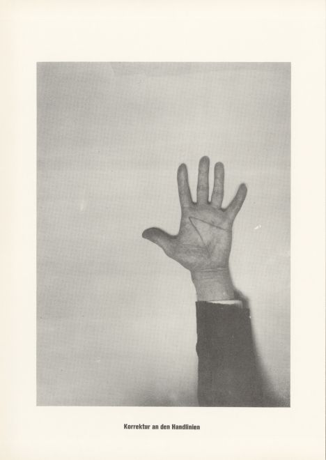 Druck von Sigmar Polke aus der Serie höhere Wesen befehlen. s/w Foto von einer Hand mit aufgemalten Linien. Darunter steht: Korrektur an den Handlinien