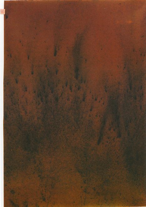 Mischung aus Polyester, Tee und PVC formt eine dunkelrote Fläche, auf der die zerriebenen Teeblätter schwarze, verwischte Spuren hinterlassen haben