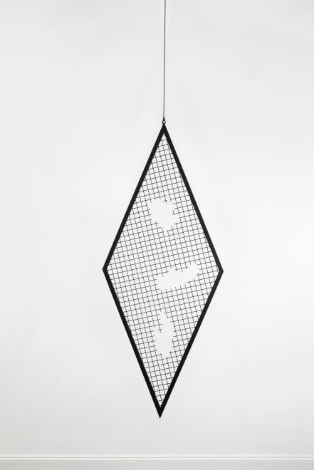 Edition von Sunah Choi. Ein rautenförmiges Gitterelement aus schwarzem, pulverbeschichtetem Stahl hängt an einem Seil von der Decke eines Galerieraumes. Aus dem Gitter wurden drei organische Formen gefräst.
