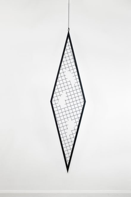 Edition von Sunah Choi. Ein rautenförmiges Gitterelement aus schwarzem, pulverbeschichtetem Stahl hängt an einem Seil von der Decke eines Galerieraumes. Aus dem Gitter wurden drei organische Formen gefräst.