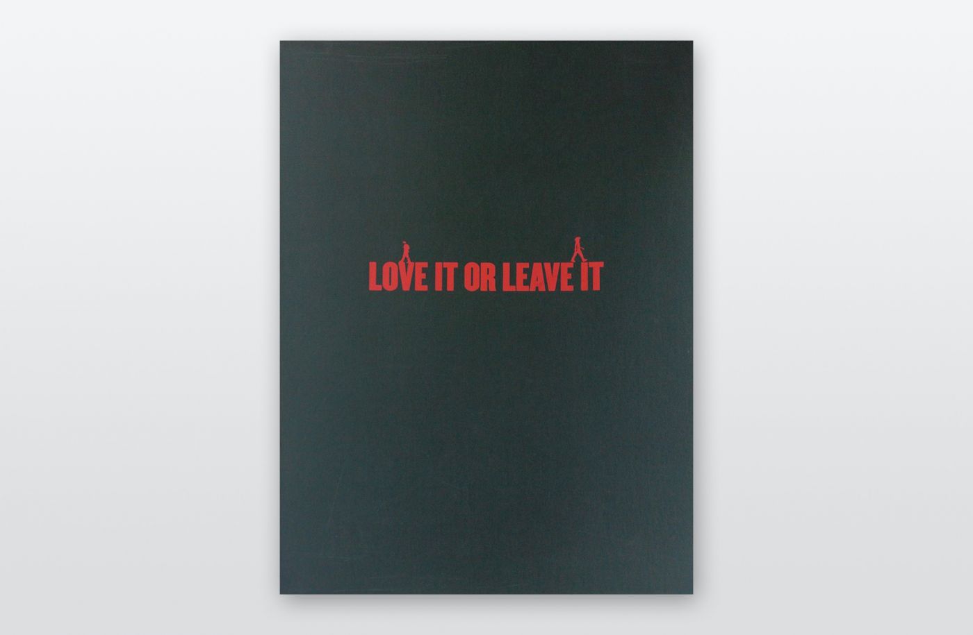 Eine dunkelgrüne Leinenkassette liegt auf grauem Hintergrund. In Rot steht darauf: LOVE IT OR LEAVE IT