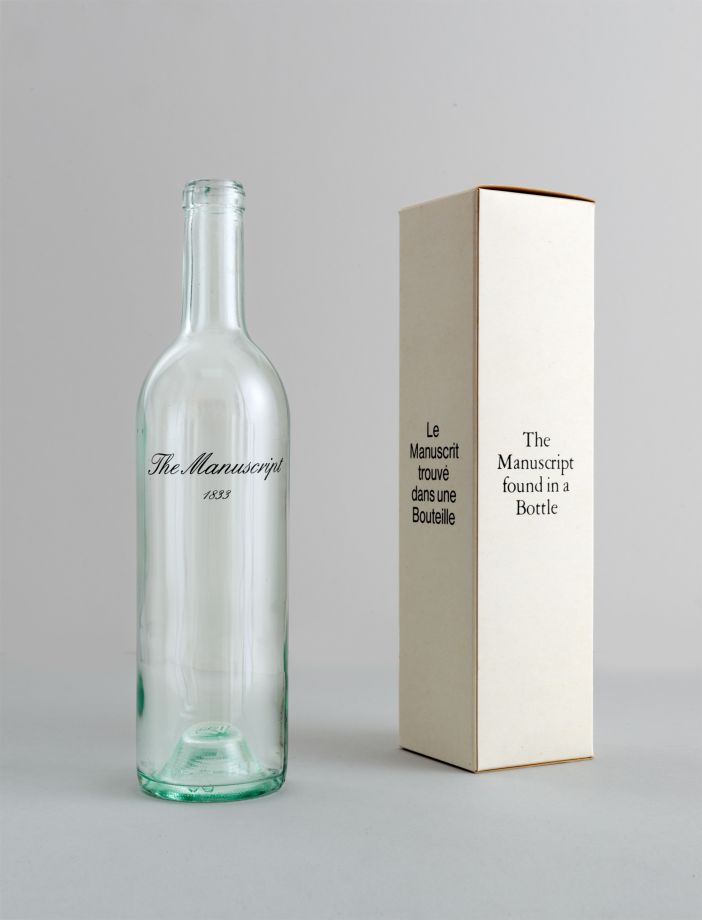 Edition von Marcel Broodthaers. Eine leere weiße Weinflasche, auf die „The Manuscript 1833“ in geschwungener Schrift gedruckt ist, steht neben einem passenden weißen Karton. Auf der einen Seite steht: Le Manuscript trouvé dans uns Bouteille, auf der anderen steht: The Manuscript found in a Bottle